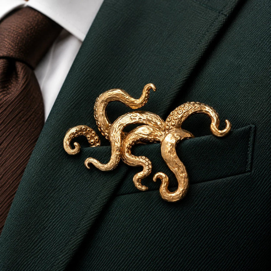 Gilded octopus brooch displayed on dark tailoring