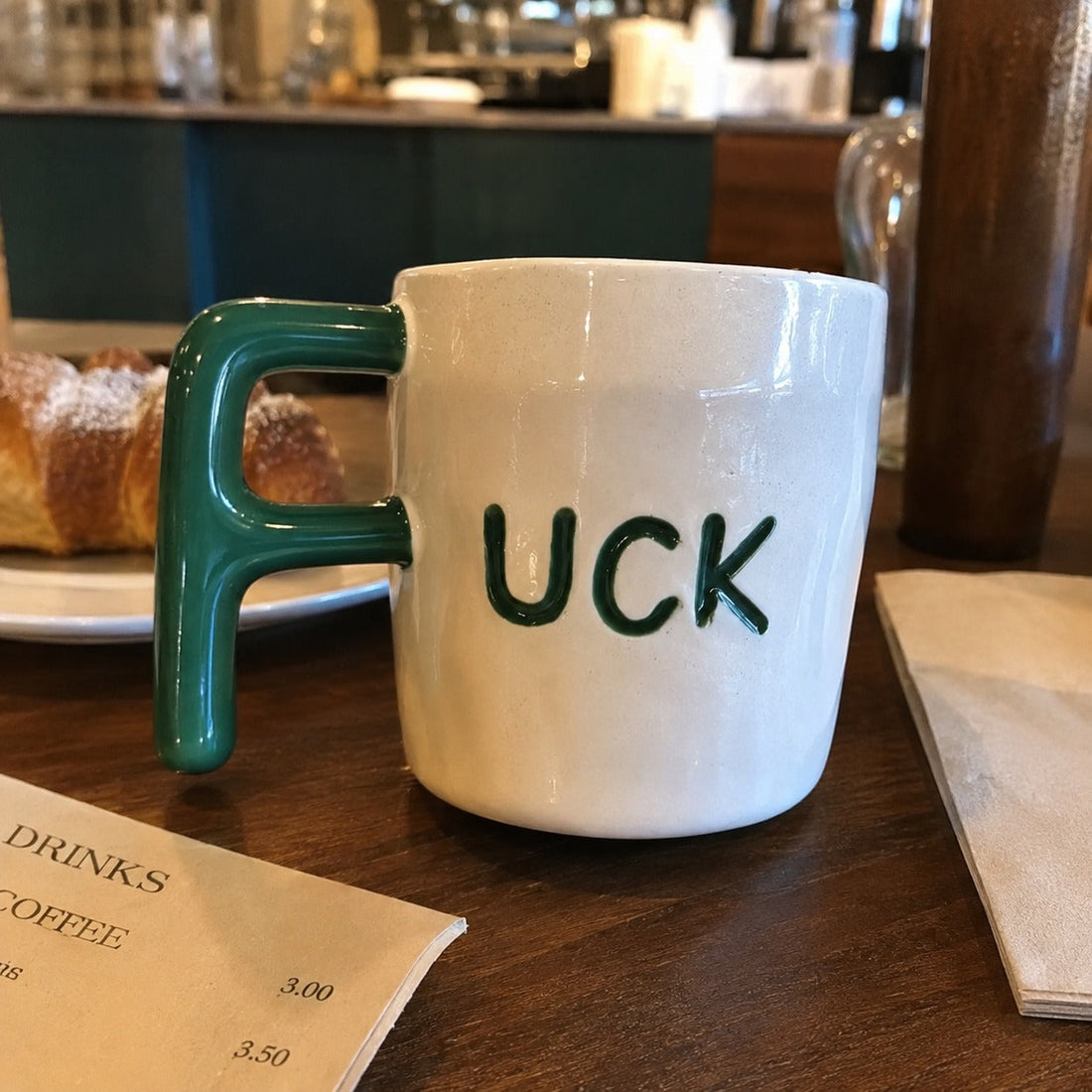 F Bomb mug on a cafe table